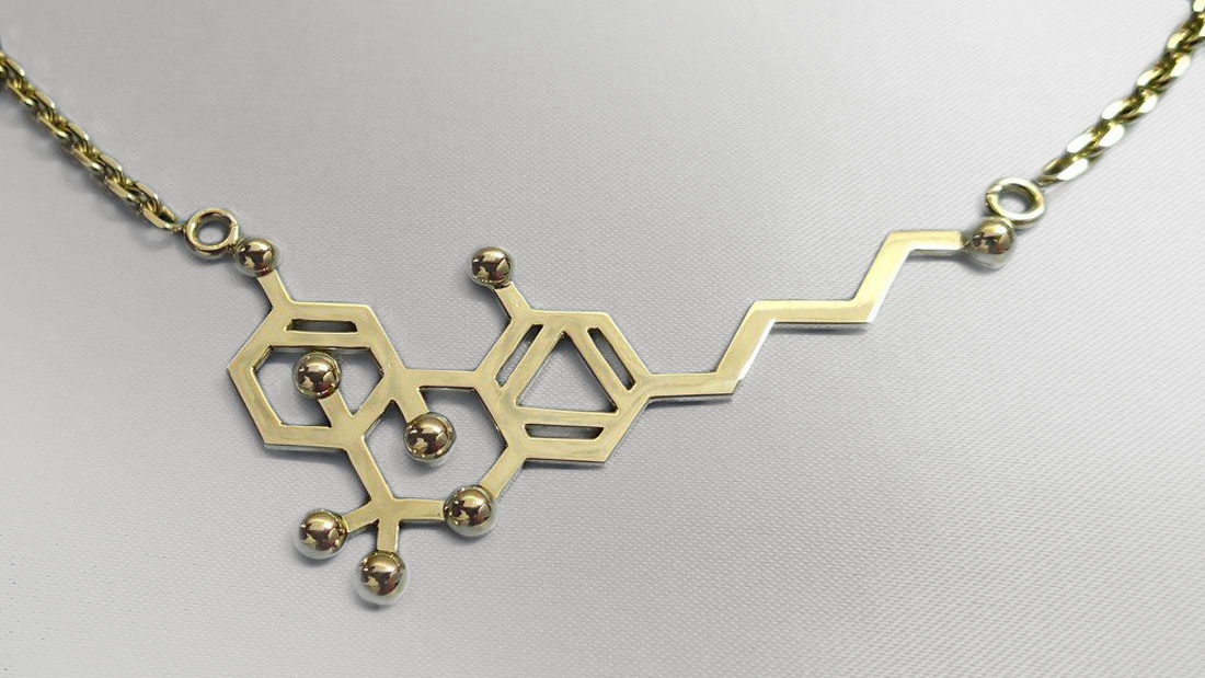 Zlatý přívěsek znázorňující molekulu THC